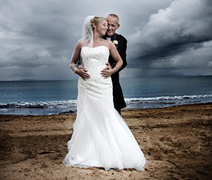 Groom holding Bride on the beach
